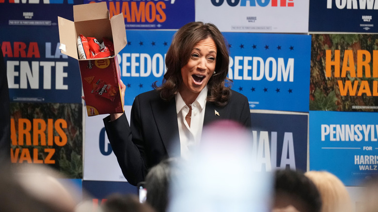 Kamala Harris holding up a box of Doritos at a campaign event