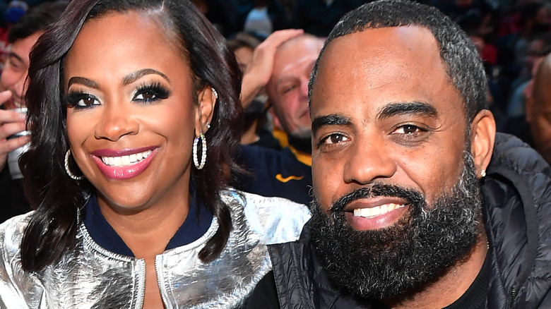 Kandi Burruss and Todd Tucker smiling at basketball game 