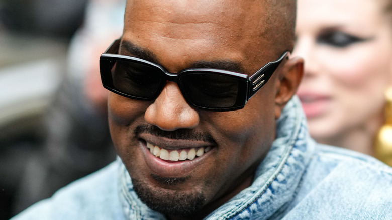 Kanye West wearing sunglasses and smiling