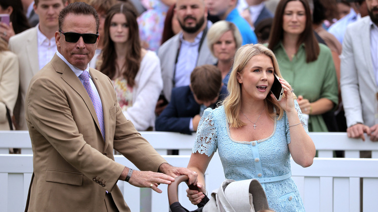 Nicholas Riccio pushing a stroller while Karoline Leavitt talks on the phone