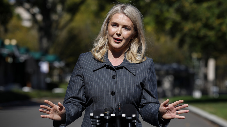 Karoline Leavitt speaks to the press while gesturing with her hands