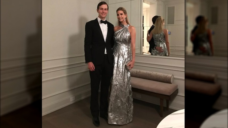 Melania Trump poses next to Jared Kushner in a metallic silver dress