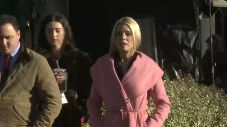 Pam Bondi poses in a pink trench coat