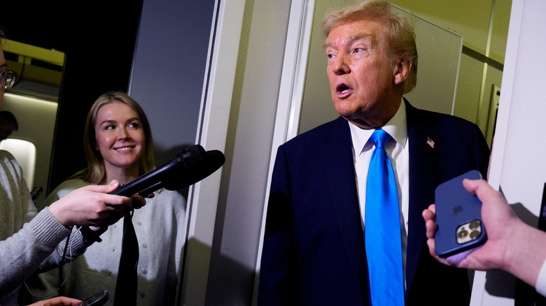 President Donald Trump speaks to members of the media aboard Airforce One in October 2025.
