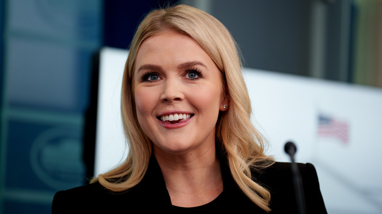 Karoline Leavitt smiling in a black suit