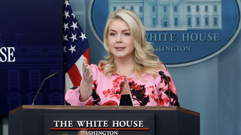 Karoline Leavitt pink floral jacket at podium gesturing