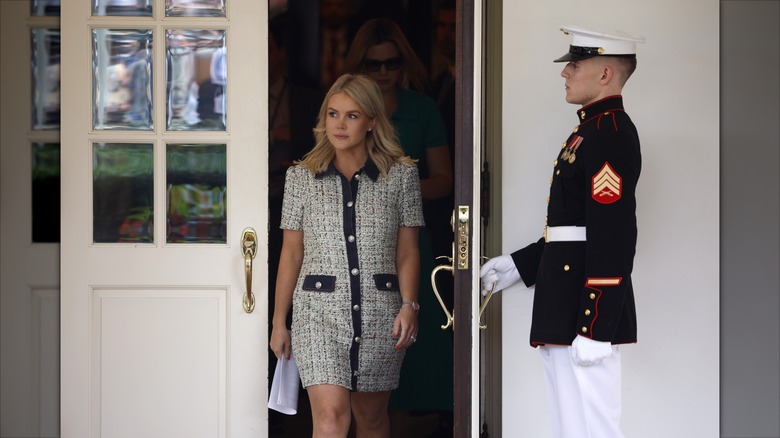 Karoline Leavitt walking out of the White House in a dress.