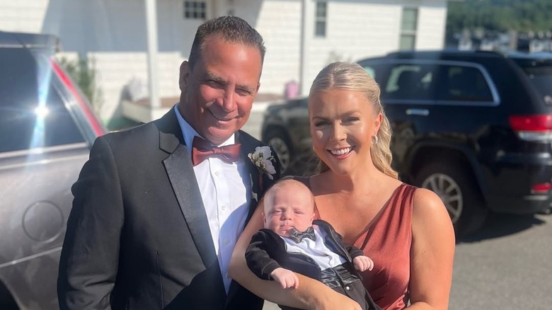 Karoline Leavitt holds her son while standing next to her husband