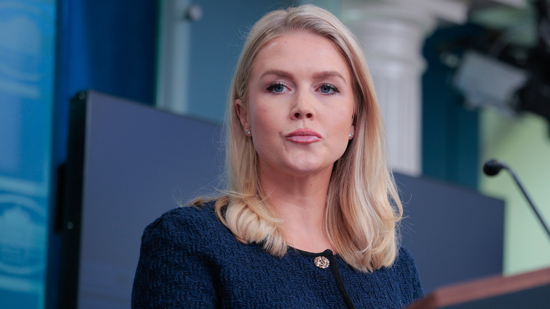 Karoline Leavitt pursing her lips in a navy blazer
