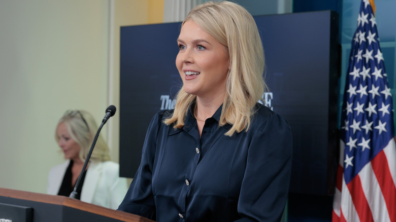 Karoline Leavitt smiling in a navy blouse