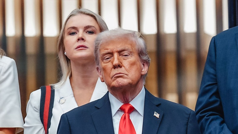 Karoline Leavitt looking over Donald Trump's shoulder