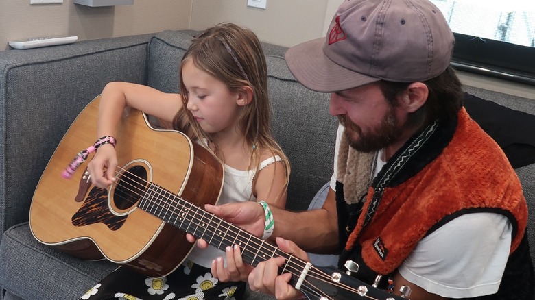 Rani Rose Hudson Fujikawa playing the guitar with her father Danny Fujikawa