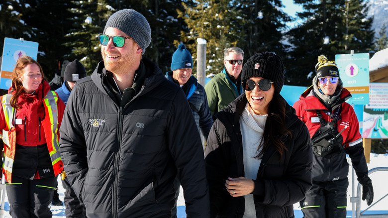 Prince Harry and Meghan Markle smiling as they walk together