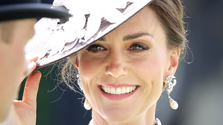 Kate Middleton wearing polka dots and smiling at Prince William
