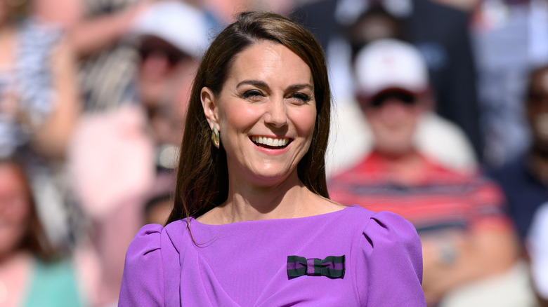Kate Middleton smiling widely in purple