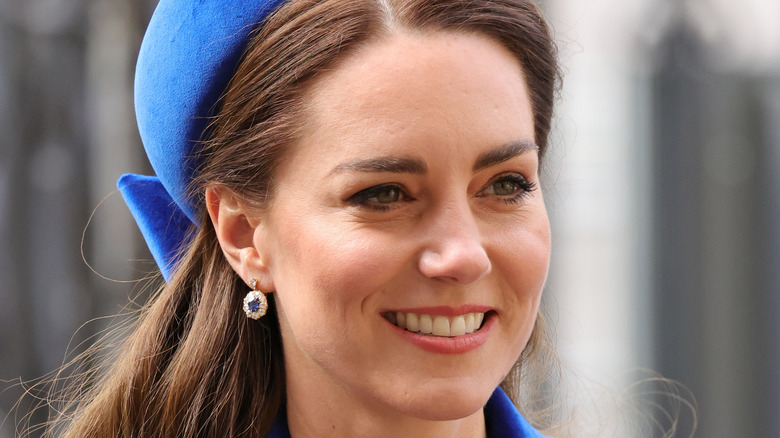 Kate Middleton smiling with blue hat and sapphire earrings