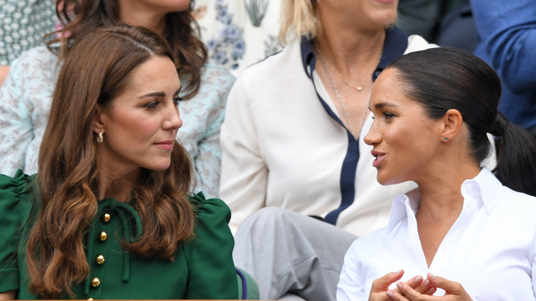 Meghan Markle and Kate Middleton looking at each other 