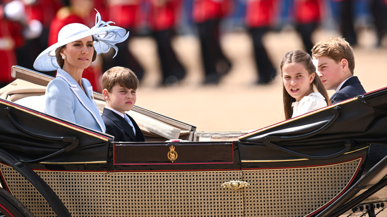 Princess Catherine riding in a carriage with her three children