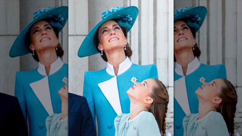 Kate Middleton smiling and looking up with Charlotte.
