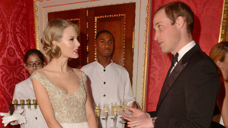 Prince William, Duke of Cambridge meets singer Taylor Swift at Kensington Palace for the Centrepoint Winter Whites Gala on November 26, 2013 in London, England.
