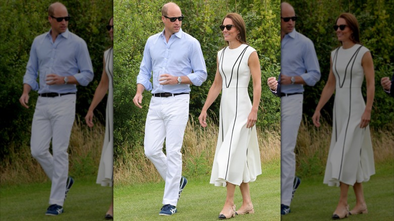 Prince William in white slacks and a blue top and Kate Middleton in a white dress with black stripes outside