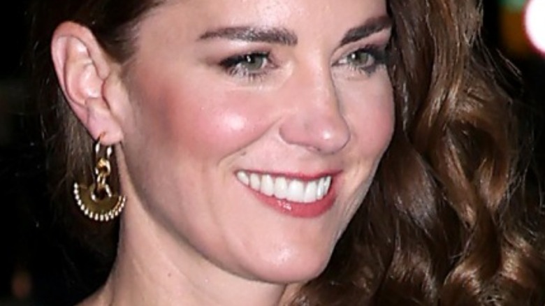 Kate Middleton in gold earrings with wide smile