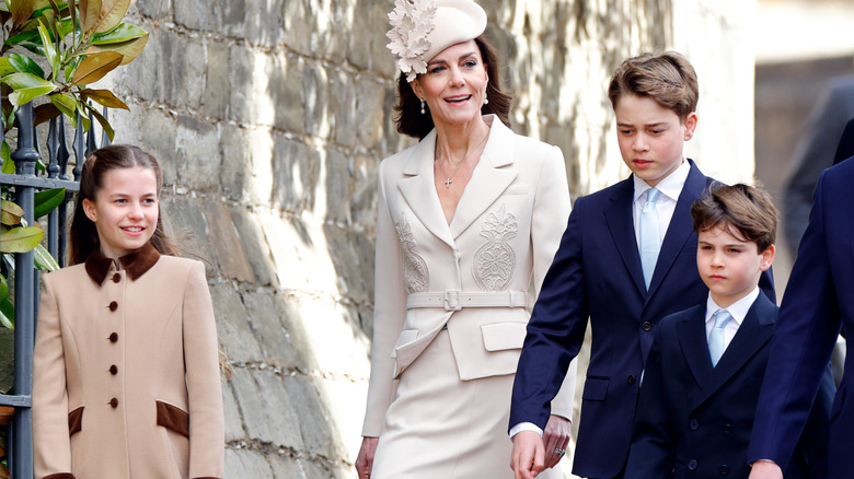 A smiling Princess Catherine walking alongside Prince George, Prince Louis, and Princess Charlotte