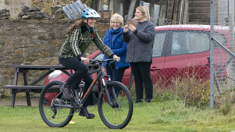 Princess Catherine biking through a field