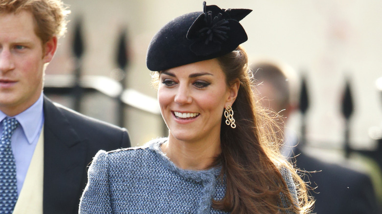 Princess Catherine smiling in a black hat.