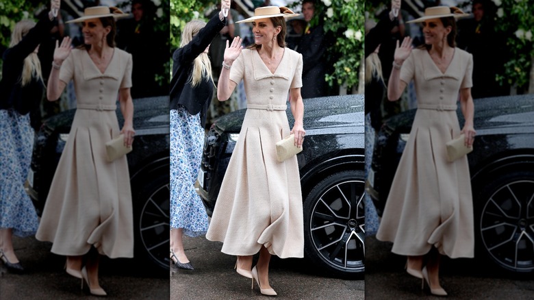 Princess Catherine holding a clutch in one hand and waving with the other.