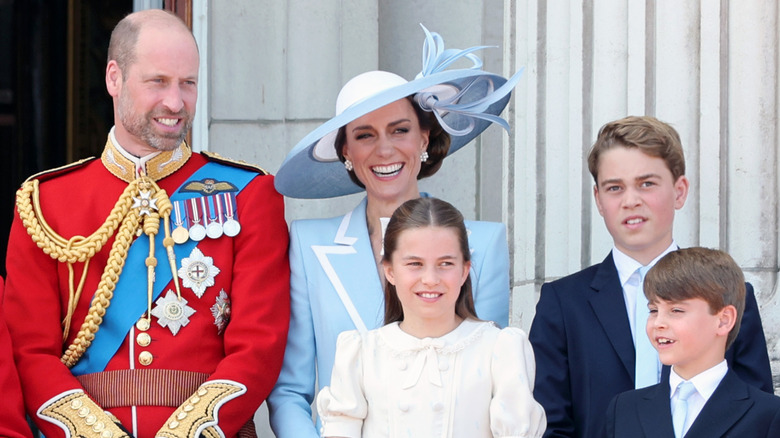 Prince William and Kate Middleton smiling with Prince Louis, Prince George, and Princess Charlotte
