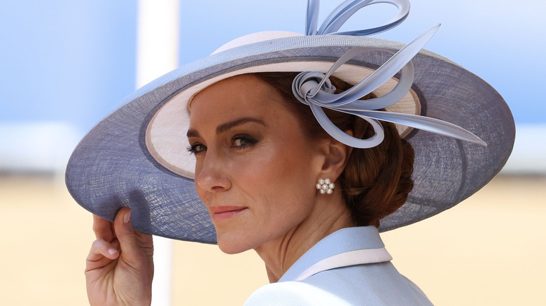 Catherine, Princess of Wales head turned holding hat brim