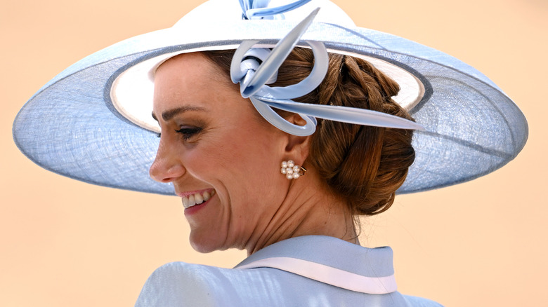 Catherine, Princess of Wales smiling and turning her head to show off her earrings
