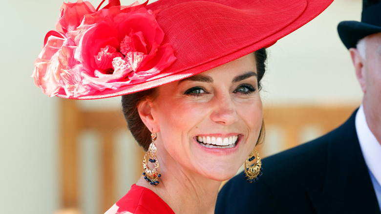 Kate Middleton smiling in red hat