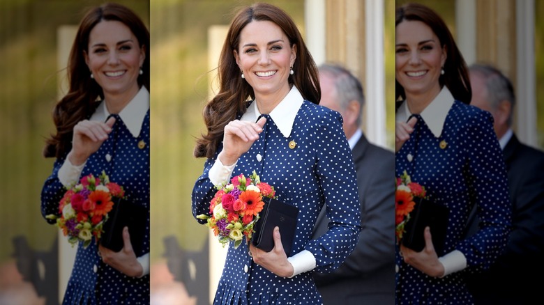 Kate Middleton smiling with a bouquet of flowers