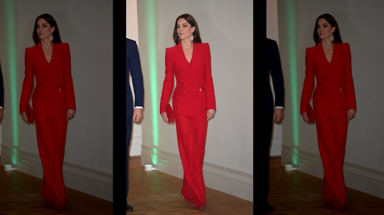 Princess Catherine walking while wearing a bright red matching pantsuit