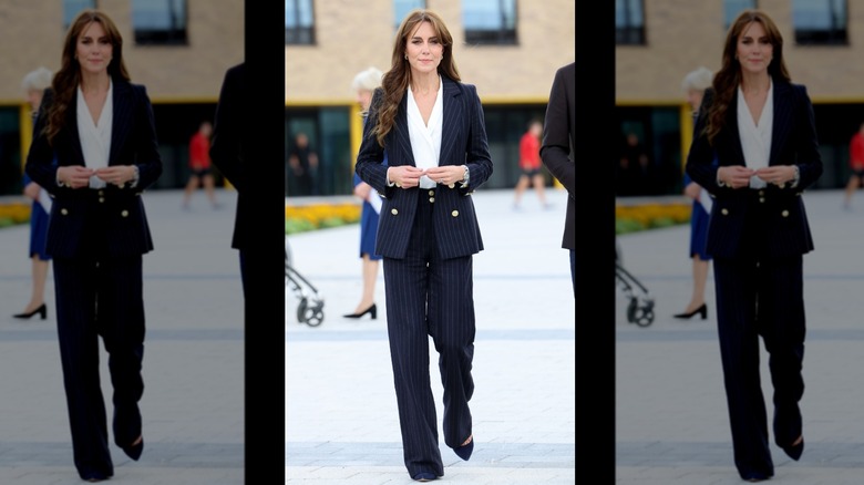 Kate Middleton walking in a pinstriped pantsuit with a white blouse underneath