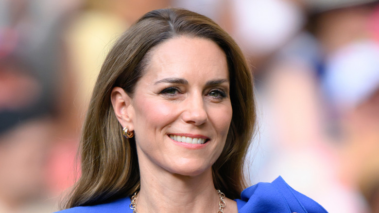 Catherien, Princess of Wales, attending clapping in a blue dress while attending the Wimbledon tennis tournament games.