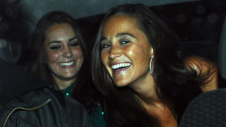 Young Kate Middleton in the back of a darkened car with Pippa Middleton.