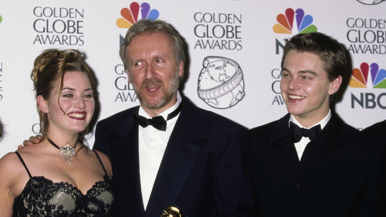 Kate Winslet posing for photos with James Cameron and Leonardo DiCaprio
