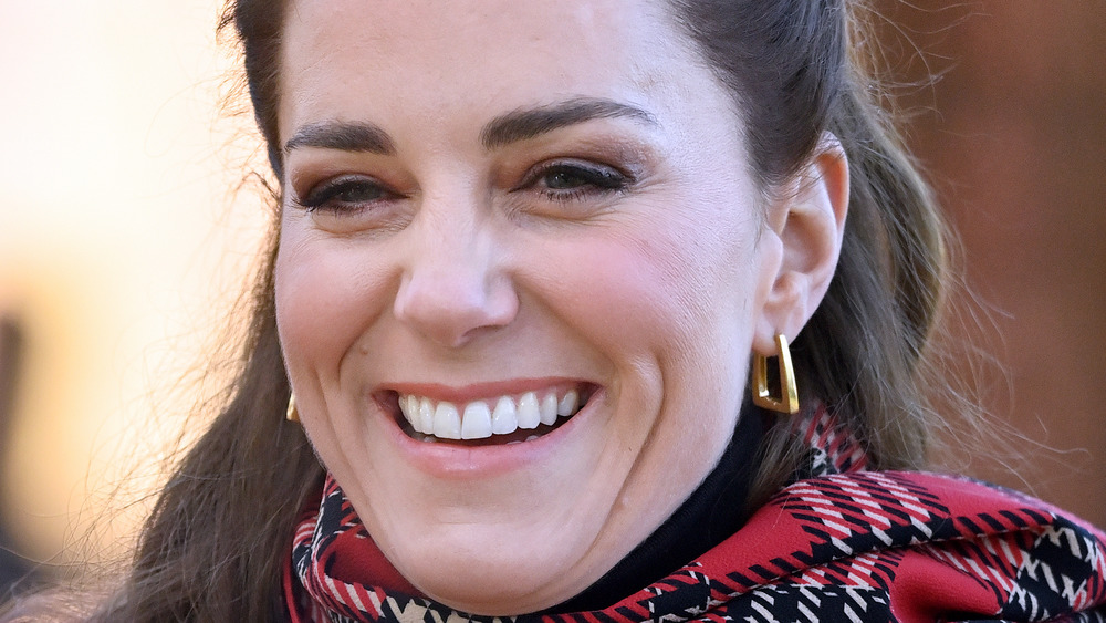 close up of Kate Middleton wearing earrings and red plaid