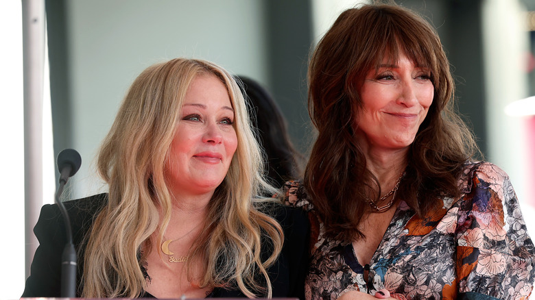 Christina Applegate and Katey Sagal smiling in front of a microphone