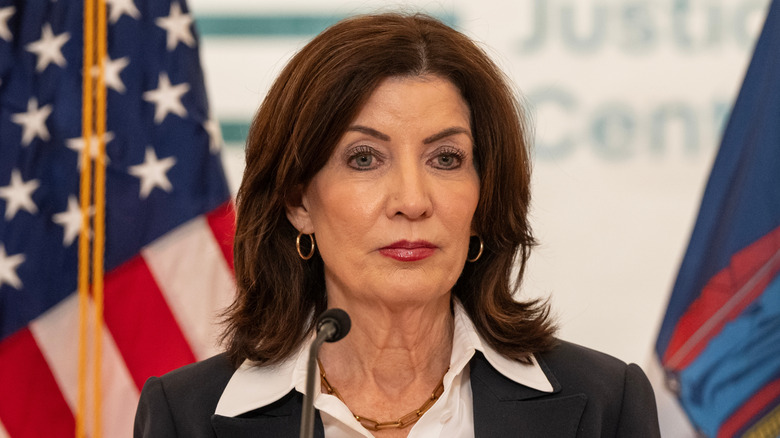 Kathy Hochul stands in front of a microphone