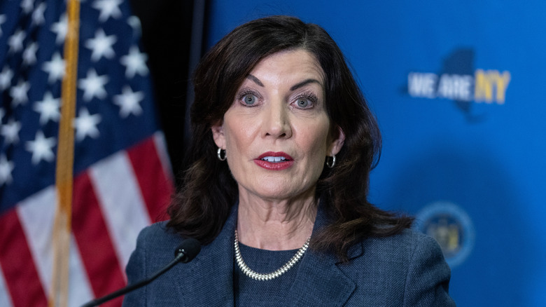 Kathy Hochul stands in front of the American flag