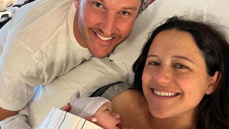 Ellie Monahan and Mark Dobrosky smile with their newborn baby