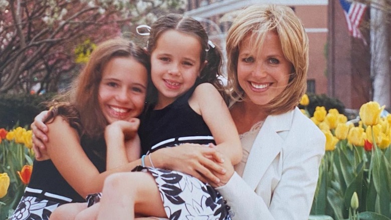 Katie Couric smiling with her young daughters