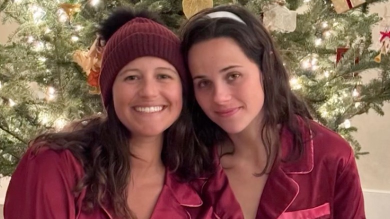 Ellie and Carrie Monahan posing in front of a Christmas tree