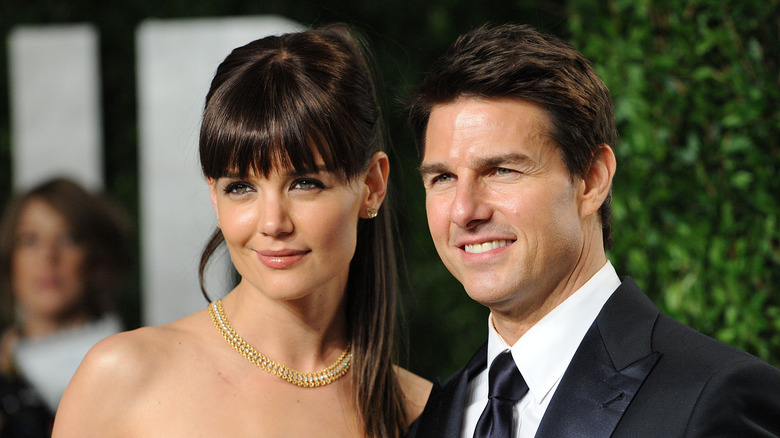 Katie Holmes and Tom Cruise gaze at cameras at a red carpet event