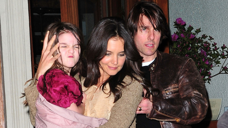 Tom Cruise walking with Katie Holmes holding Suri