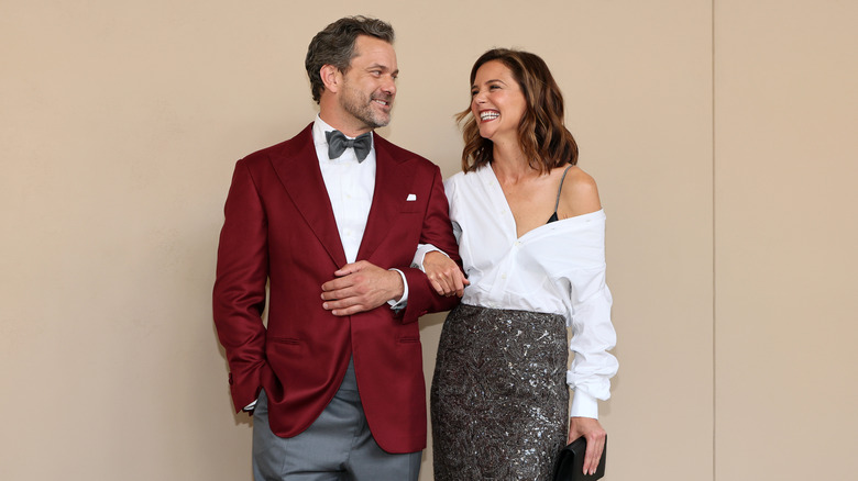 Joshua Jackson and Katie Holmes posing together with wide smiles on the red carpet